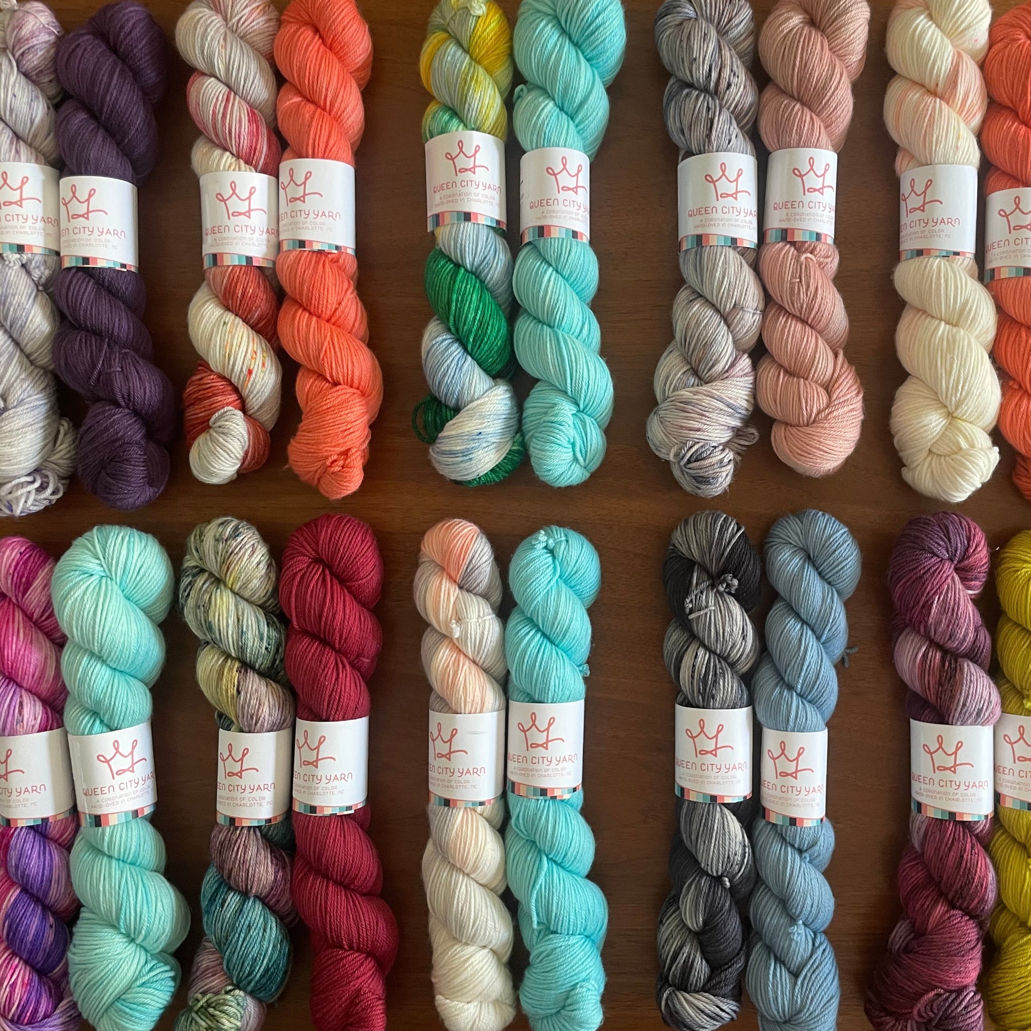 Assorted skeins of yarn in various colors on a wooden surface
